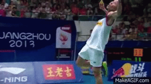 A Man Is Jumping In The Air In Front Of A Sign That Says 2013 GIF