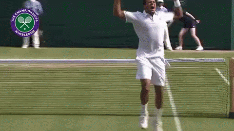 a man is jumping in the air on a tennis court in front of a logo for the wimbledon championships