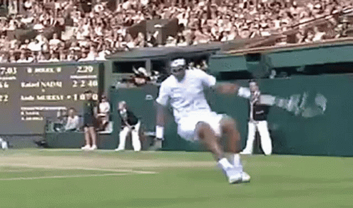 a man is jumping in the air while playing tennis on a court .