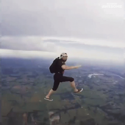 A Man Is Jumping In The Air With A Backpack On His Back GIF