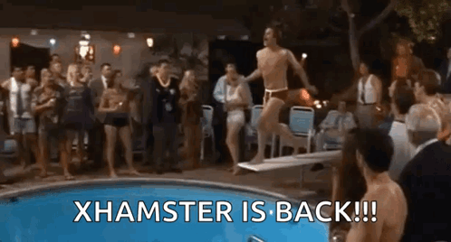 A Man Is Jumping Off A Diving Board Into A Pool While A Group Of People Watch . GIF