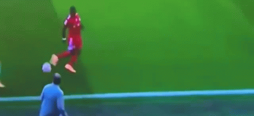 A Man Is Kicking A Soccer Ball On The Field GIF
