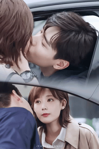 A Man Is Kissing A Woman On The Cheek In A Car While A Woman Looks On GIF