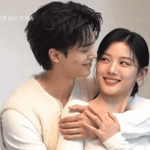 A Man Is Kissing A Woman On The Cheek With A Ring On His Finger GIF