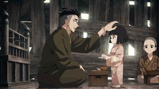 A Man Is Kneeling Down And Petting A Little Girl 'S Head While A Group Of Children Sit Around Him . GIF