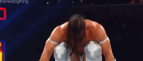 A Man Is Kneeling Down In A Boxing Ring Wearing White Gloves And Knee Pads . GIF