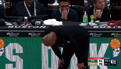 A Man Is Kneeling Down In Front Of A Sign That Says Boston GIF