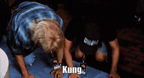 A Man Is Kneeling Down With The Word Kung Written On His Hands GIF