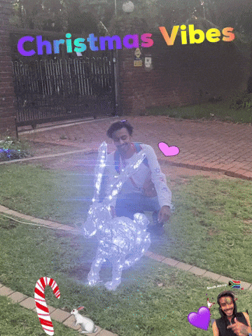 A Man Is Kneeling In Front Of A Christmas Decoration GIF