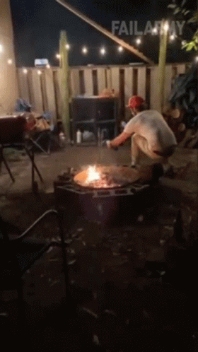 A Man Is Kneeling In Front Of A Fire Pit With Failarmy Written Above Him GIF