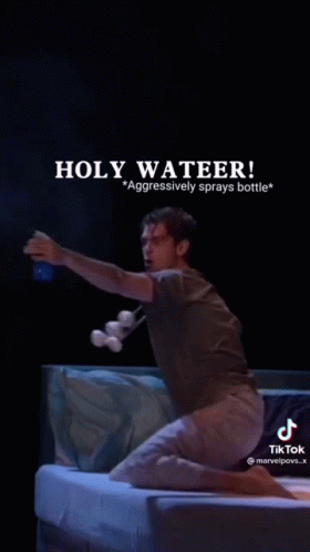 A Man Is Kneeling On A Bed Holding A Bottle Of Water And A Bottle Of Marshmallows . GIF