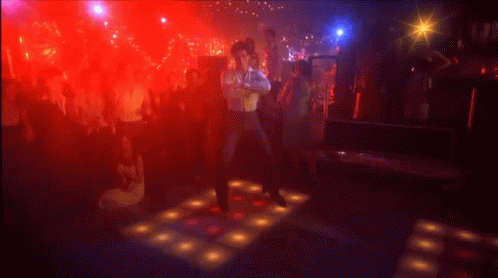 A Man Is Kneeling On A Dance Floor In A Club . GIF