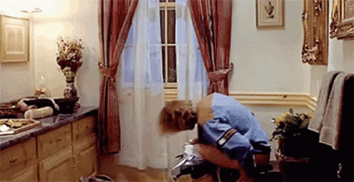 A Man Is Kneeling On A Toilet In A Bathroom . GIF
