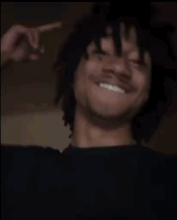 A Man Is Laughing And Giving The Middle Finger While Wearing A Black Shirt . GIF