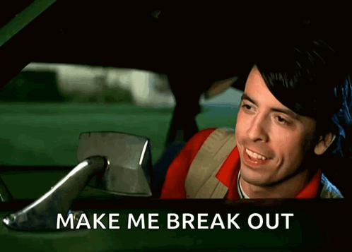 A Man Is Laughing In A Car With The Words Make Me Break Out Above Him GIF