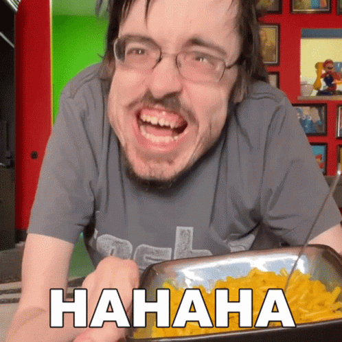 A Man Is Laughing While Holding A Tray Of Macaroni Cheese GIF