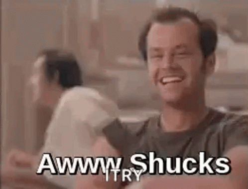 A Man Is Laughing While Sitting At A Table With Another Man . GIF