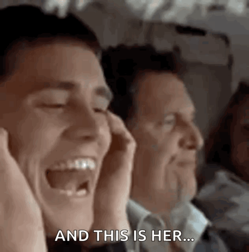 A Man Is Laughing While Sitting Next To Another Man On A Plane While Holding His Hands To His Ears . GIF