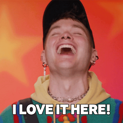 A Man Is Laughing With The Words " I Love It Here " Behind Him GIF