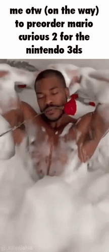 A Man Is Laying In A Bathtub Holding A Rose In His Mouth . GIF