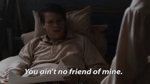 A Man Is Laying In A Bed With A Piece Of Paper And A Woman Is Standing Next To Him . GIF