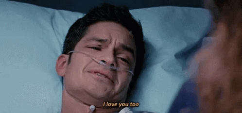 A Man Is Laying In A Hospital Bed With An Oxygen Mask And Crying . GIF
