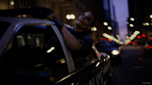 A Man Is Laying In A Police Car With The Words Tech Noir On The Bottom GIF