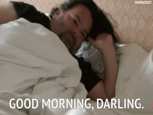 A Man Is Laying In Bed With The Words " Good Morning Darling " On The Bottom GIF