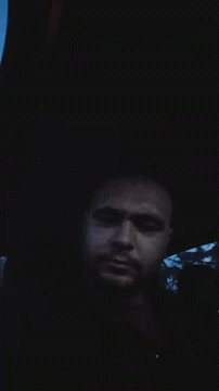 A Man Is Laying In The Dark With His Eyes Closed GIF