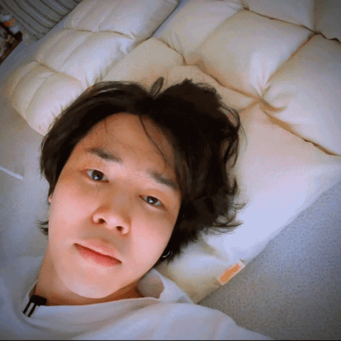 A Man Is Laying On A Bed With A Pillow That Says ' A ' On It GIF