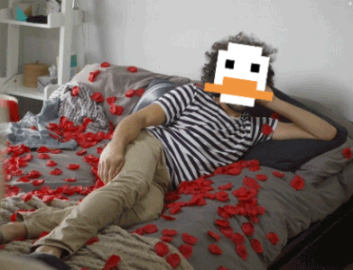 A Man Is Laying On A Bed With A Pixelated Duck Face On His Face GIF