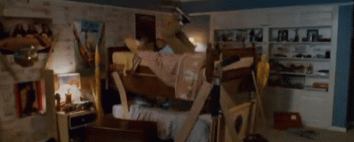 A Man Is Laying On A Bunk Bed In A Room With A Sign On The Wall That Says ' A ' On It GIF