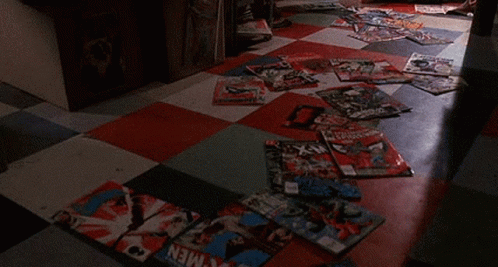 Man Lying On Checkered Floor Surrounded By Magazines GIF