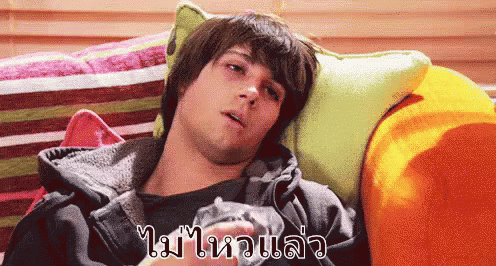 A Man Is Laying On A Couch With A Foreign Language Written On The Bottom Right GIF