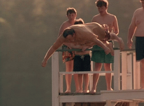 A Man Is Laying On A Giant Inflatable Shark That Says The Blob On It GIF