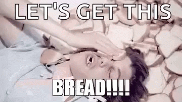 A Man Is Laying On A Pile Of Bread With His Hand On His Face . GIF