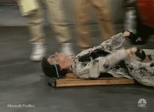 A Man Is Laying On A Wooden Plank With A Nbc Logo On The Bottom GIF