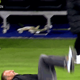 A Man Is Laying On His Stomach On A Soccer Field GIF