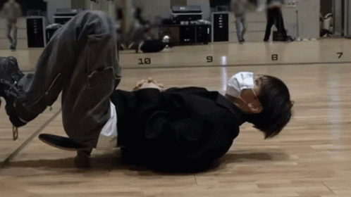 A Man Is Laying On The Floor Wearing A Mask And Headphones GIF