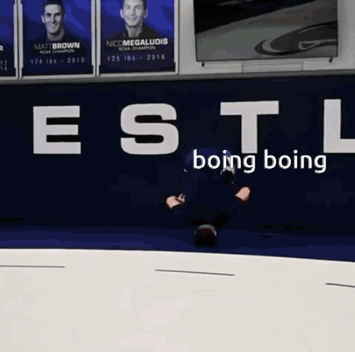 A Man Is Laying On The Ground In Front Of A Wall That Says " Estl Boing Boing " GIF