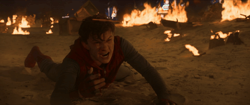 A Man Is Laying On The Ground In Front Of Fires GIF