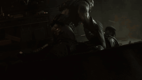 A Man Is Laying On The Ground While Another Man Stands Behind Him GIF