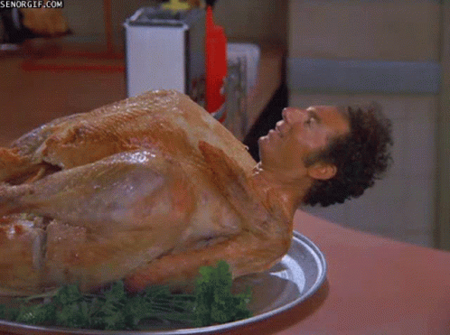 A Man Is Laying On Top Of A Turkey On A Tray GIF