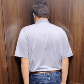 A Man Is Leaning Against A Wall With His Head Down GIF