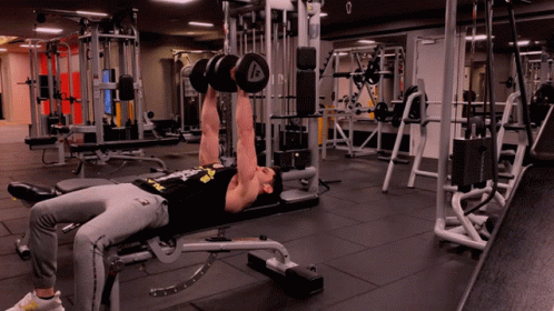 A Man Is Lifting Dumbbells In A Gym With The Letter A On The Dumbbell GIF