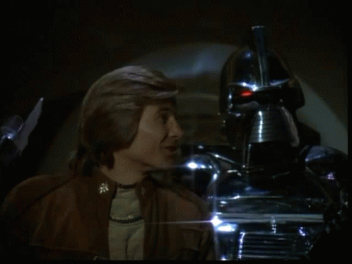 a man is lighting a cigarette in front of a silver robot