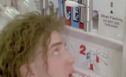 A Man Is Looking At A Sign That Says " When Flashing Do Not Use This Side " GIF