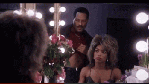 A Man Is Looking At A Woman In A Dressing Room GIF