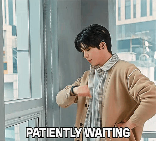 A Man Is Looking At His Watch With The Words Patiently Waiting Behind Him GIF
