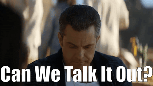 A Man Is Looking Down With The Words Can We Talk It Out Behind Him GIF